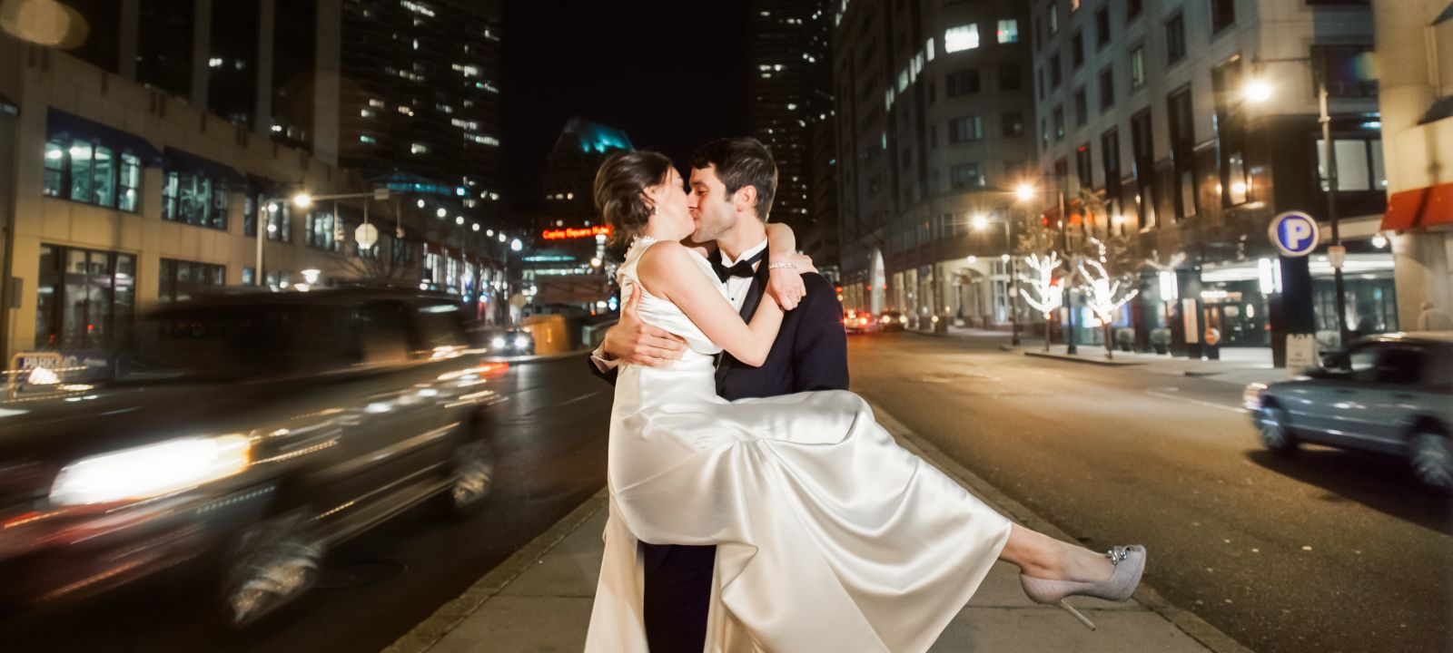 Bridge and groom kissing on street at night